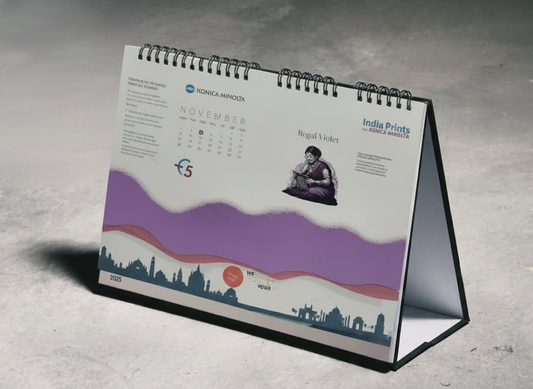 Tabletop calendar with a purple and white design on a gray surface