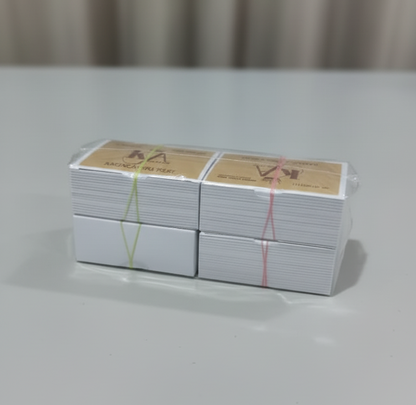 Stack of white cards with red and yellow text on a gray surface