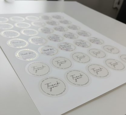 Sheet of round stickers with 'Thank you' text on a white surface