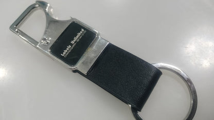 Keychain with black leather strap and metal clip on a white background