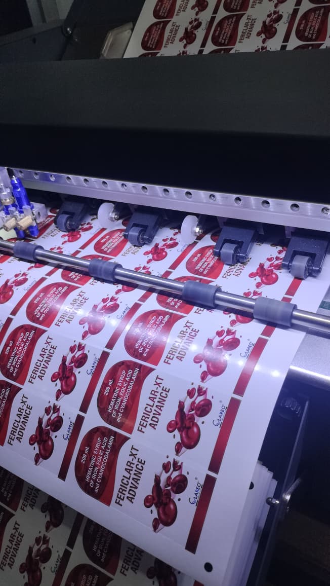Printing press with printed product featuring red and white design.