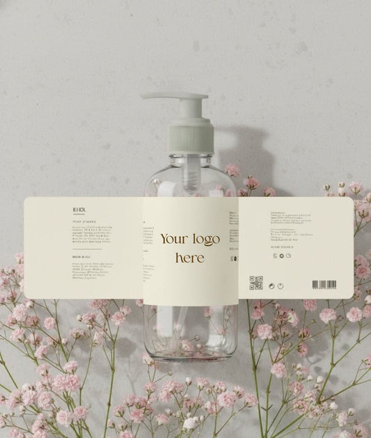 Clear bottle with pump and label on a gray background with pink flowers